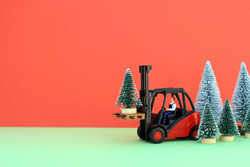 An isolated artificial Christmas tree being carried by a scale model forklift truck. Delivered in...