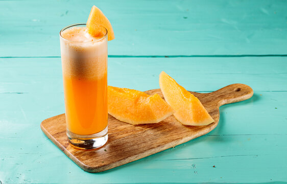 Sweet Melon Juice with raw Sweet Melon served in a glass isolated on cutting board side view healthy fruit juice