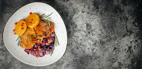 roast duck leg red cabbage on a dark background. Long banner format. top view