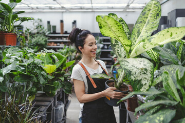 Obraz premium Shot of a young woman working with plants in a garden centre