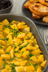 Stewed pumpkin slices in an oval dish close up with ricotta cheese and toasted croutons, top view, seasonal autumn food