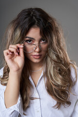 Attractive young business woman in glasses on gray