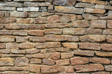 A wall of large old yellow stone blocks. Pattern and texture of stone wall background. Natural stone background.