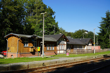 Historic small railroad station in the village Barthmuehle with tracks and the old station building in half-timbered construction. Vogtland district, Saxony, Germany, Europe.