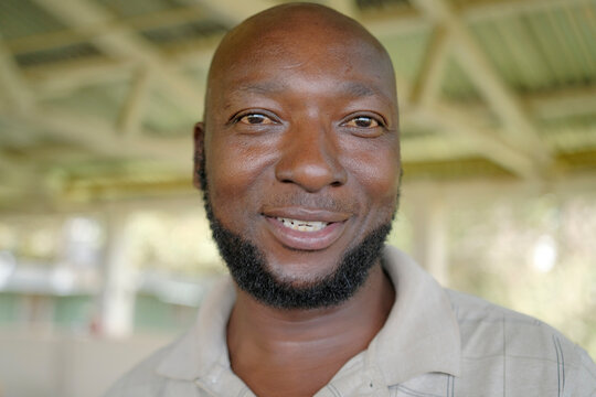 Black bald 40 year old man with a beard smiles. Satisfied and happy African man