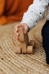 Children's hand with a wooden toy close-up