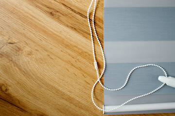 Obraz premium A sample of the finished fabric blind of the day and night system on a wooden background, copy space