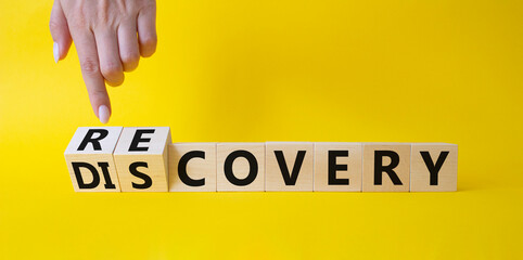 Recovery and Discovery. Businessman points at wooden cubes with words Recovery and Discovery. Beautiful yellow background. Business concept. Copy space