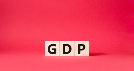 GDP - Gross domestic product symbol. Concept word GDP on wooden cubes. Beautiful red background. Business and GDP concept. Copy space.