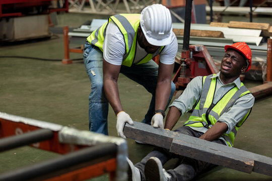 Industrial accident concept. Male african american accidents from working carrying heavy objects on legs in Industrial factory.