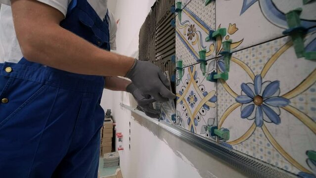 Construction, renovation, repair apartment. Installing ceramic wall tiles - measuring and cutting the pieces. Cuts tile. Tile cutting.