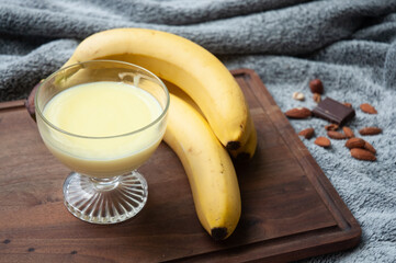 Banana pudding dessert in a glass cup on a cutting board.