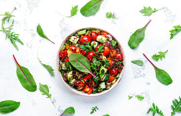Quinoa tabbouleh salad with tomatoes, paprika, avocado, cucumbers and parsley. Traditional Middle Eastern and Arabic dish. White kitchen table background, top view