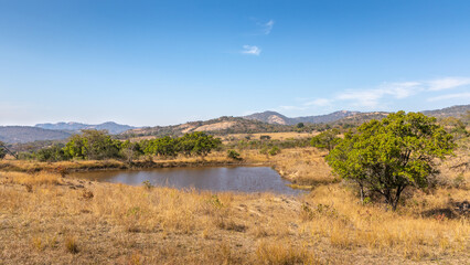 Small dam with view into the hills across the wetland, Mbombela, South Africa.