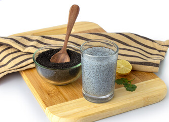 Basil seeds in bowl with seeds drink in glass on wooden board