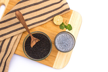 Basil seeds in bowl with seeds drink in glass on wooden board
