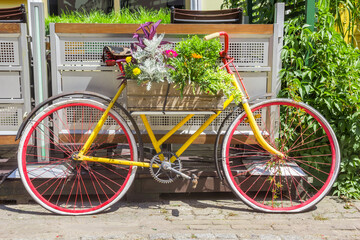 Fototapeta na wymiar Colorful red and yellow bicycle decorated with flowers in Plock, Poland