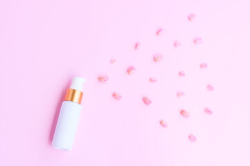 White parfume bottle spray with Pink Mexican creeper flowers(Antigonon leptopus) on pink background