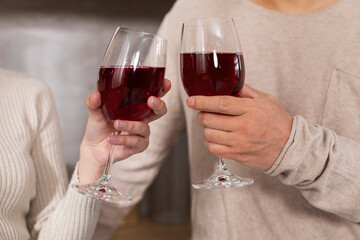 Unrecognizable spouses enjoying time together, drinking wine, cropped