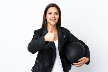 Caucasian girl holding a motorcycle helmet on white background giving a thumbs up gesture