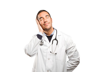 Fototapeta premium Happy doctor sleeping against white background