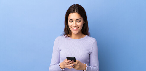 Young caucasian woman over isolated background sending a message with the mobile