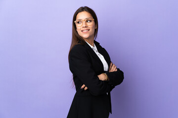 Business woman isolated on purple background with arms crossed and happy