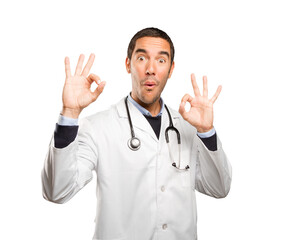 Satisfied doctor with an okay gesture against white background