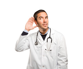 Surprised doctor with listen gesture against white background