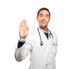 Young doctor showing his palm against white background