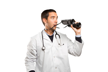 Surprised doctor using a binoculars against white background