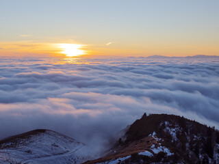 sunset in the mountains above the fog, italian alps