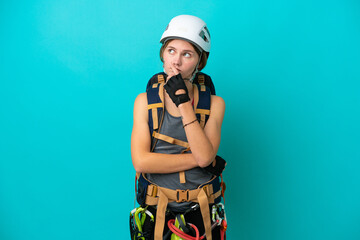 Young English rock climber woman isolated on blue background having doubts and with confuse face expression