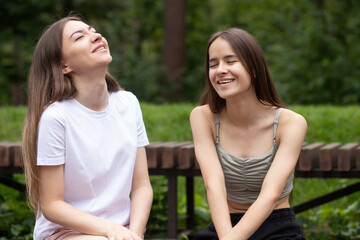 Obraz premium laughter and fun in summer, young women laughing in the park, happy friends relaxing in nature