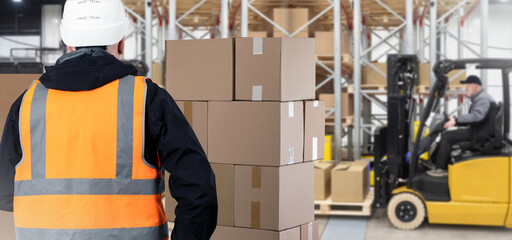 Custom warehouse. Man customs officer and boxes. Guy in yellow vest with her back to camera. Tiered racks and forklift blurred. Customs warehouse with cardboard boxes. Career storage worker. - obrazy, fototapety, plakaty