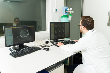 Fototapeta na wymiar Radiologist looking at the brain resonance in the computer at the lab