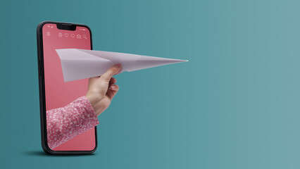 Hand holding a paper plane in a smartphone
