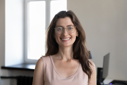 Happy pretty young business professional woman in glasses head shot portrait. Millennial entrepreneur, female leader, employee in casual looking at camera, smiling, posing in office