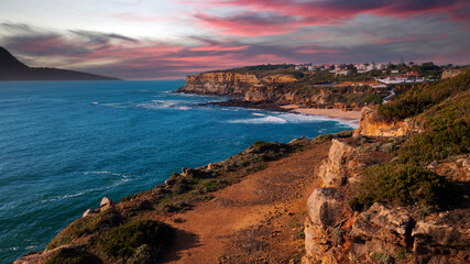 Beautiful landscape of  rocky ocean coastline during sunset.  Aerial view of a small European town against cloudy sky, sandy beach and Atlantic Ocean while sunset. Top view  Beautiful natural beauty.