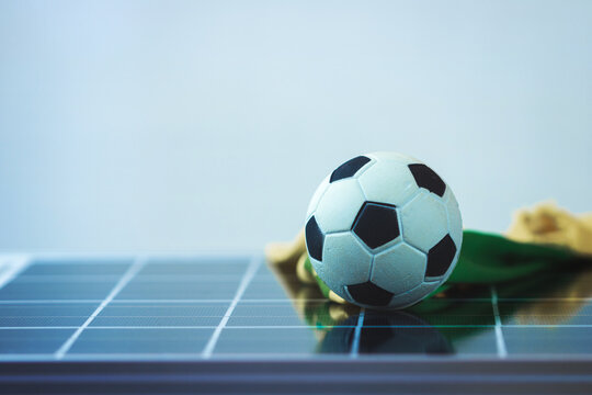 Soccer ball on photovoltaic solar panel isolated. Sport and technology concept image.