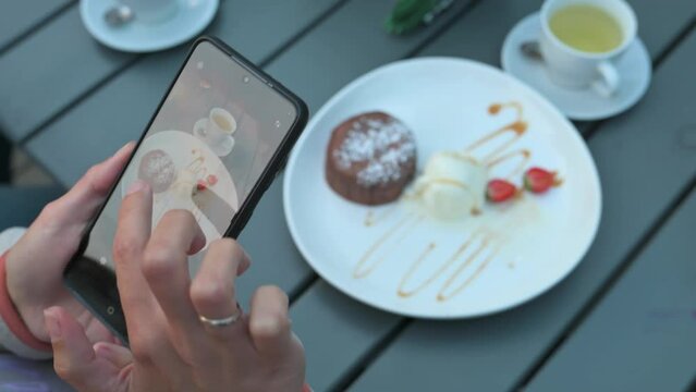 Woman taking fotos on breakfast. Shooting desser. 4k video footage
