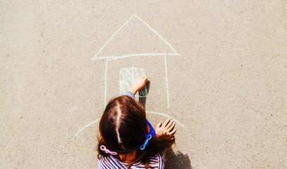 Children draw on the pavement with chalk. Selective focus.