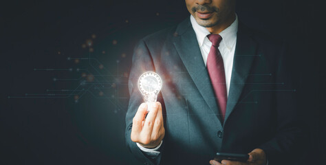 Innovation through ideas and inspiration ideas. Businessman hand holding light bulb to illuminate,...