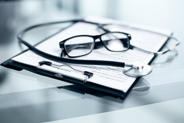 Doctor table with medicines, stethoscope and glasses, top view