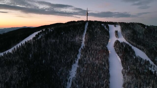 4K Aerial winter sunrise or sunset view of Rhodope Mountains and Snezhanka tower near resort of Pamporovo, Smolyan Region, Bulgaria