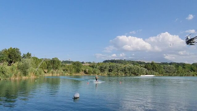 Young man practicing cable wakeboarding on the lake