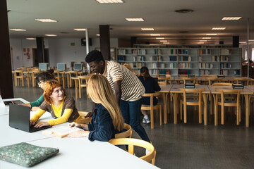 Young diverse people studying in library - School education concept