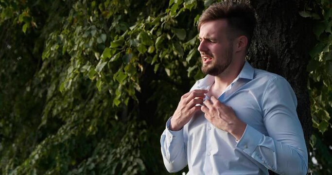 Man having heart attack near tree in park