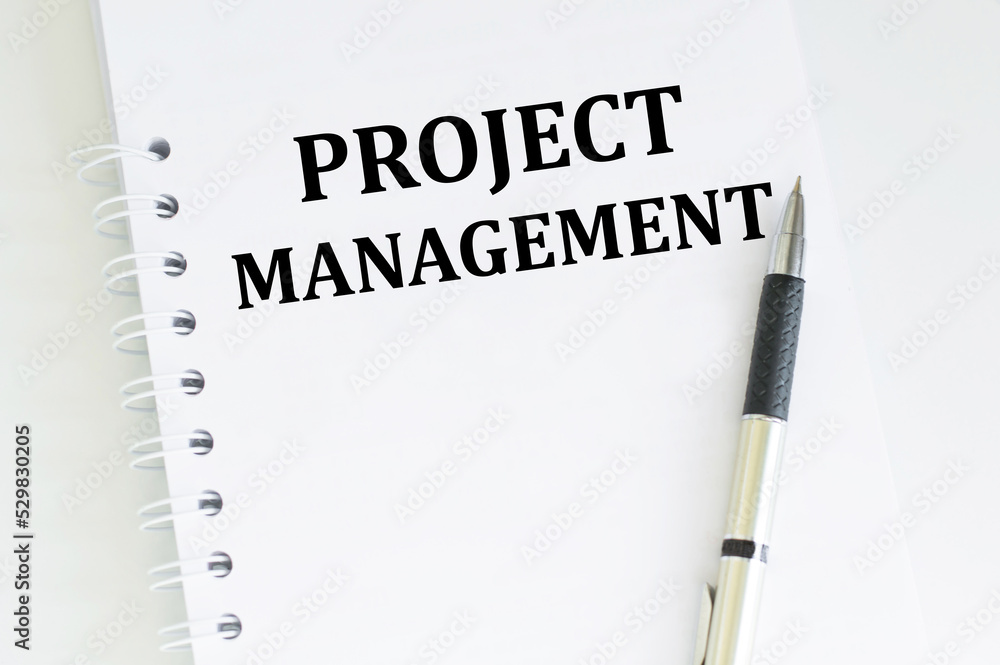 Poster project management text on a notebook worksheet on the desk