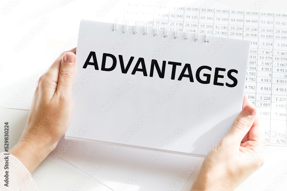 Poster advantages text on a notebook in the hands of a girl on the background of a table, business concept.